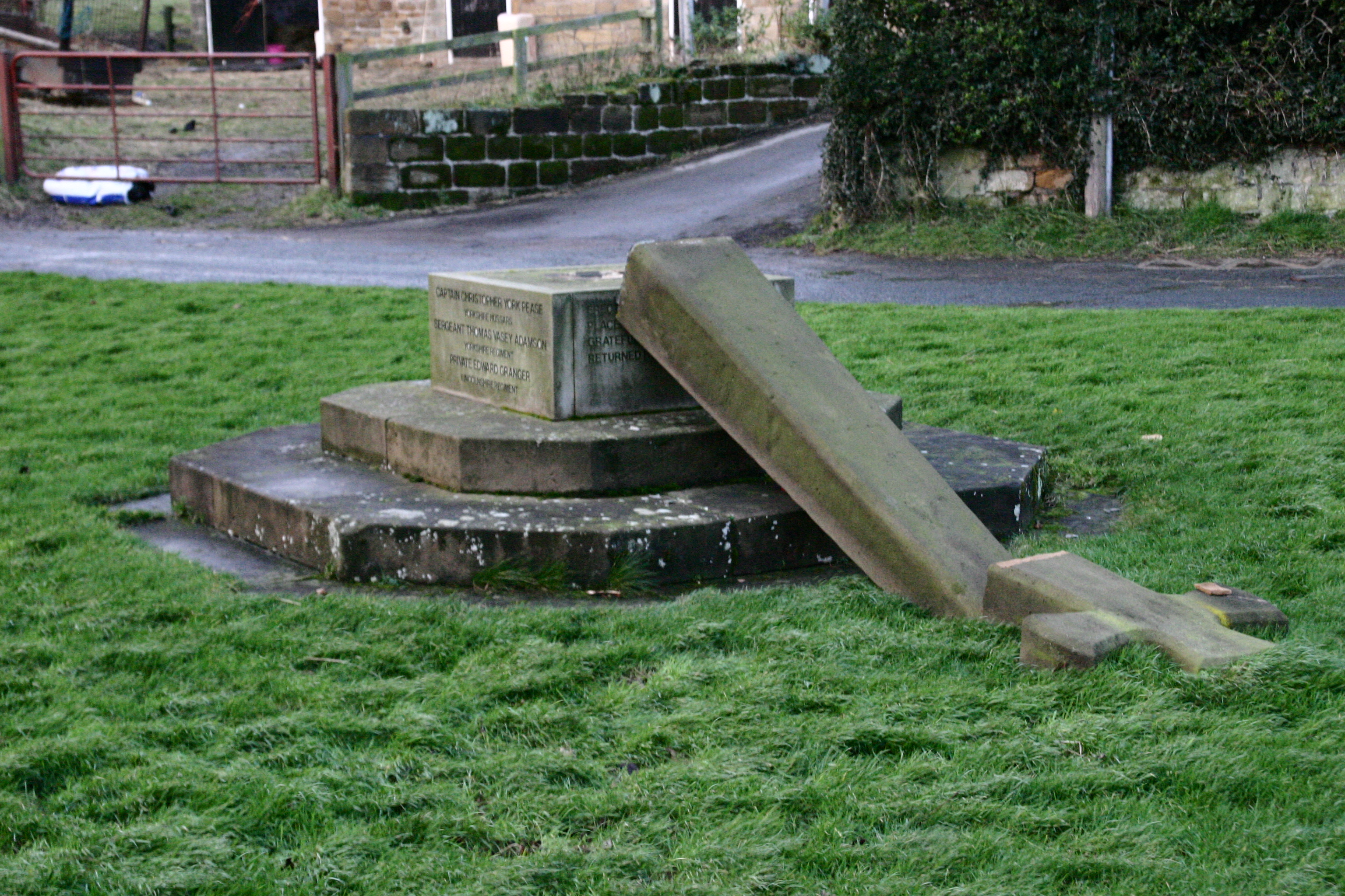 Ingleby Cross War Memorial Toppled over laying on the grass